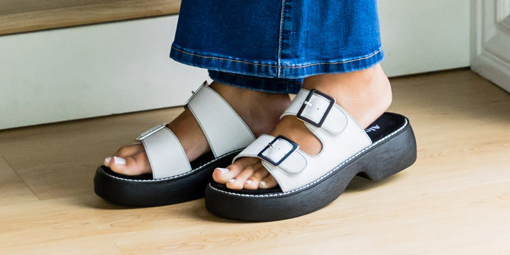 Iza white sandal with adjustable hook and loop strap closures on platform outsole.
