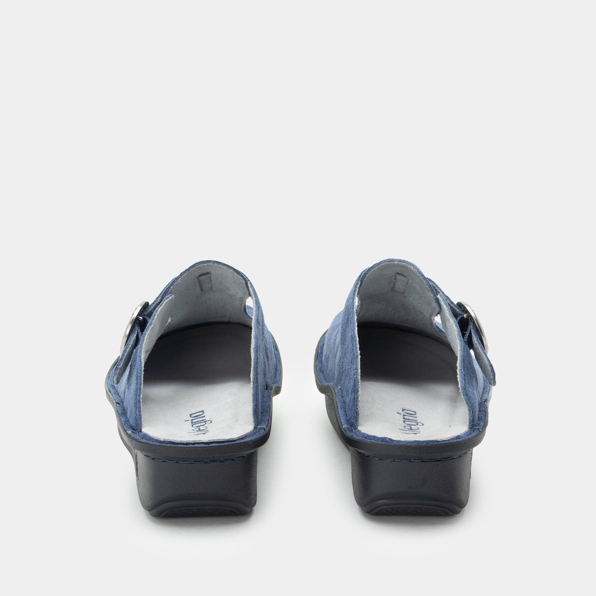 Shimmer Blue  suede slip-on clogs shown from the back, featuring a blue suede upper with a dark sole and heel, and grey suede leather lining. ALG-6559