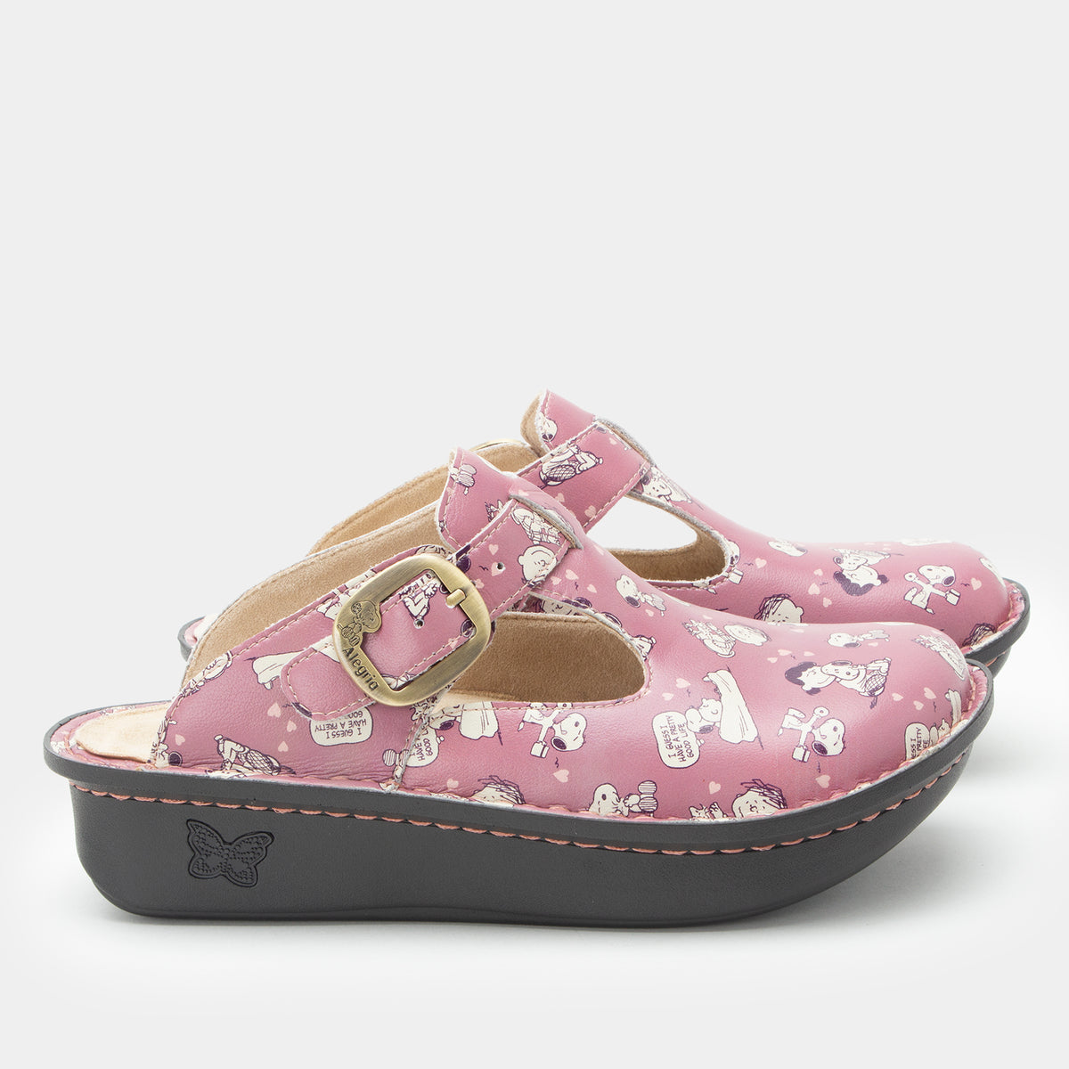 Classic Rose Snuggles Side view of a pink slip on clog featuring Peanuts®  character doodle on a Classic rocker outsole- showing brass buckle hardware.