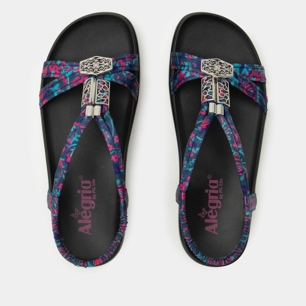 Roz Noche Flora t-strap sandal | Multi colored floral braided vegan uppers and decorative sliver hardware.