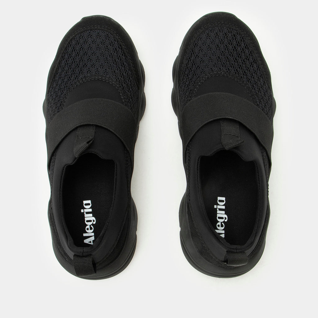 Sleek Joy Black Out shoe on a lightweight EVA Boom Joy outsole. | Black slip-on shoe with an elastic vamp strap.