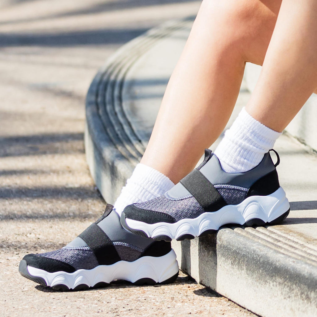 Sleek Joy Slate Grey shoe on a lightweight EVA Boom Joy outsole. | Grey slip-on shoe with black details and an elastic vamp strap.