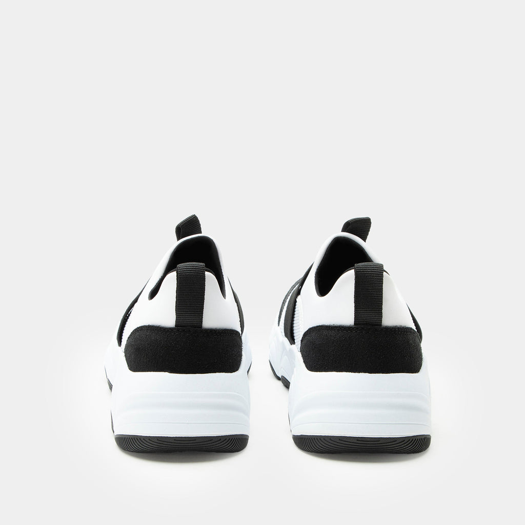 Sleek Joy Panda shoe on a lightweight EVA Boom Joy outsole | White slip-on shoe with black details and an elastic vamp strap.